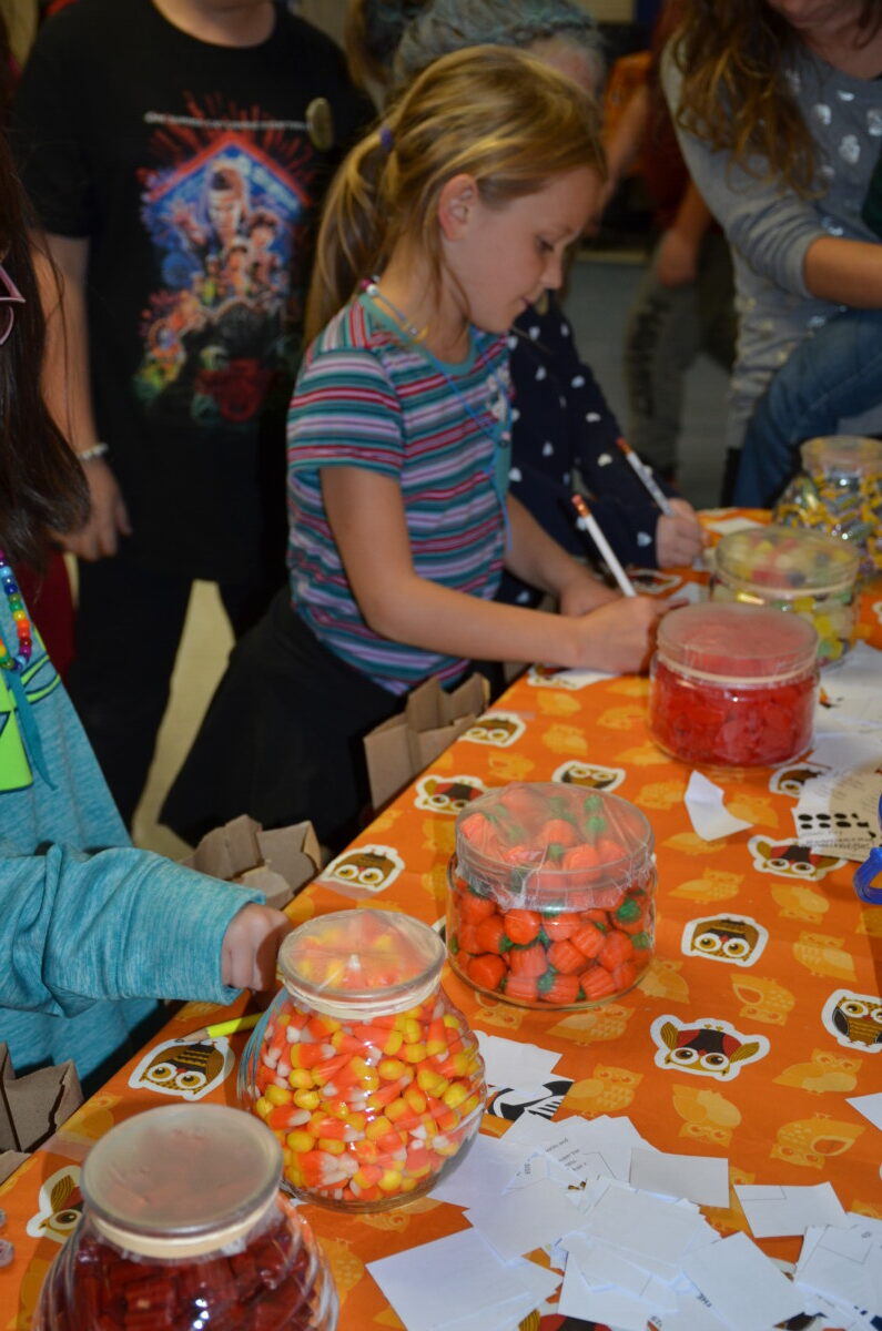Students mark their guesses at the guess how many game during the fall festival