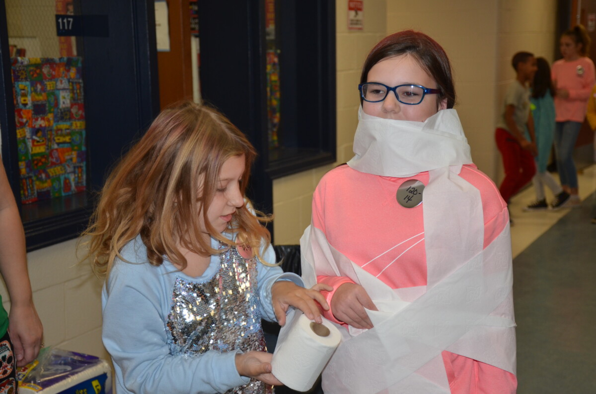 Students playing mummy game at the fall festival