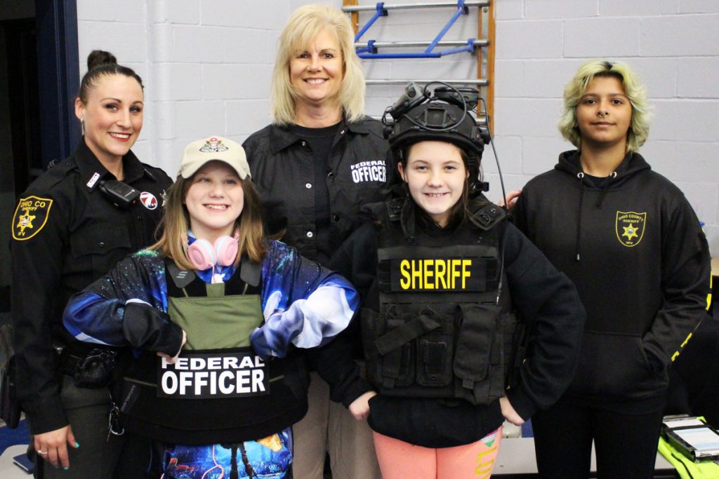 Law enforcement was one of more than 40 careers featured at the fair Saturday morning. Pictured from left in the front row wearing police gear are Central Elementary 5th graders Kristen Snyder and Peyton McBroom. Back row from left: Ohio County sheriff's deputy Brenda Lesnett, U.S Probation Officer Leslie Stocking and Mikayla Baciak. 