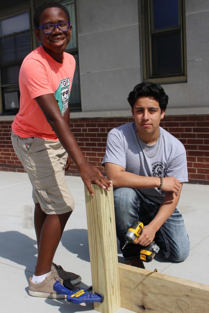 Pictured from left putting a leg on one of the raised garden beds are Central Elementary fifth-grade student Avanalist Jackson and JMHS junior Rodrigo Deleon, who is enrolled in Monarch Carpentry. 
