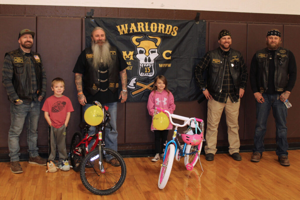 Kids and Warlords Motorcycle Club members with the new bikes.